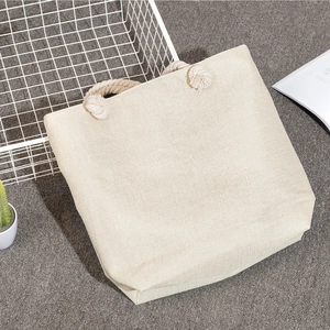 Detailed texture of blank canvas beach tote with thick braided rope handle on grey carpet
