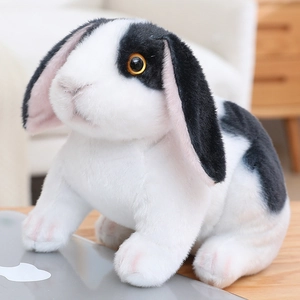 Gros plan sur la fourrure du lapin en peluche avec oreilles tombantes et broderies