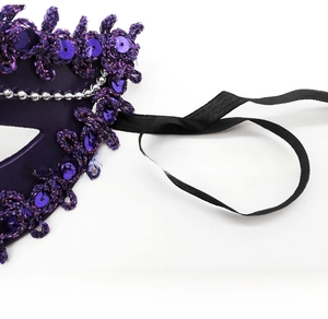 Detail view of purple lace masquerade mask with sequins and silver beaded trim decor