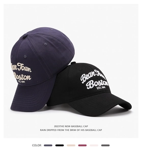 Detail of 3D embroidery on navy and black baseball caps with Bean Town Boston text