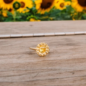 Elegant S925 silver sunflower ring with yellow zircon on a rustic wood background