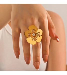Détail d'une bague fleur plaquée or 18 carats avec perle sur la main d'un mannequin