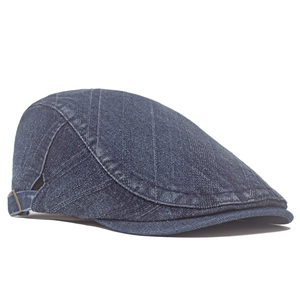 Vista laterale del cappello piatto vintage in denim blu scuro lavato con fibbia
