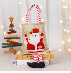 Detail of Christmas burlap gift bag featuring a 3D Santa doll and striped handles