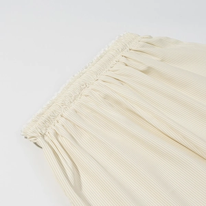 Détail de taille élastique avec dentelle et fines rayures sur un pantalon beige décontracté