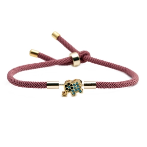 Adjustable rose pink woven rope bracelet featuring a golden elephant charm with blue stones