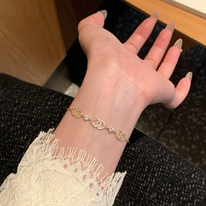 Close-up of 18k gold-plated bracelet featuring interlocking CC rings with zircon stones