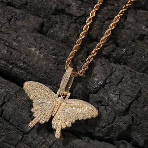 Close-up of hip hop butterfly pendant with white crystals and gold twisted rope chain
