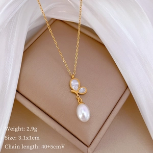 Detail of gold butterfly necklace with pearl on soft fabric and jewelry box display