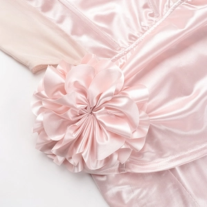 Close-up of elegant pink satin fabric with a handcrafted 3D flower detail on the dress