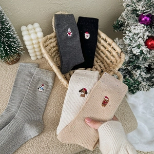 Chaussettes de Noël douillettes avec broderie bonhomme de neige en cinq couleurs dans un panier