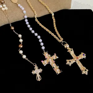Vintage Baroque cross necklaces with pearls and colorful gemstones on black velvet stand