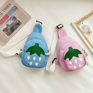 Flat lay of pink and blue strawberry canvas cross-body bags for kids with cute embroidery