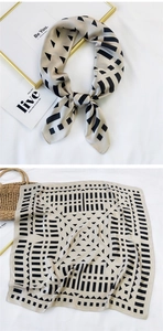 Detail of champagne silk scarf with black geometric patterns and folded styling