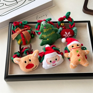 Close-up of 6 plush Christmas hair scrunchies featuring reindeer and Santa in a tray
