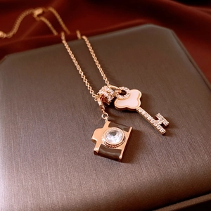 Detailed macro view of rose gold key and camera pendants with zircons and enamel