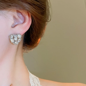 Detailed view of 18k gold plated silver stud earring with sparkling heart zircon on ear