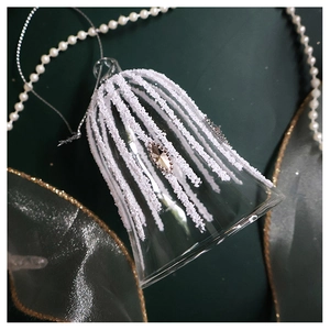 Macro detail of glass Christmas bell ornament with white stripes and rhinestone accent