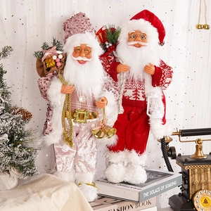 Detail of plush Santa figurines in sequined pink and classic red outfits with festive props
