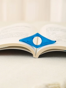 Vista macro di un supporto per pagine di libri in acrilico blu trasparente su libro