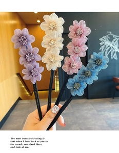 Detailed set of four colorful fabric floral hair clips in purple, white, pink, and blue