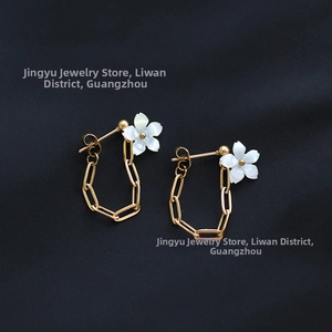 Detailed macro of gold plated floral chain earrings with white mother of pearl petals