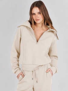 Detail of beige knit sweatshirt with half-zip stand collar and ribbed cuffs design