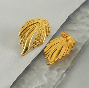 Détail des boucles d'oreilles ailes en acier inoxydable doré à texture de blé