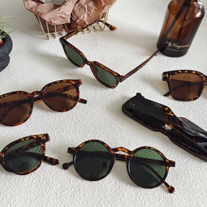 Chic leopard print and solid polygon sunglasses on a white textured marble table