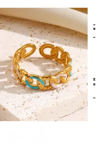 Detail of gold chain link ring featuring pink and light blue enamel on stone background