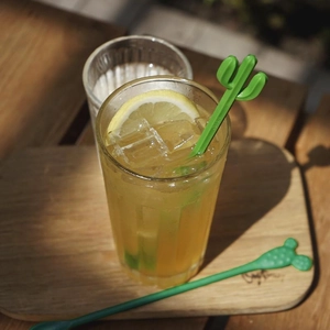 Creative cactus-shaped long handle beverage stirrers in a glass with lemon and ice