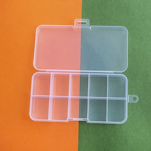 Detailed top view of 10-compartment transparent plastic storage box on a dual-tone background