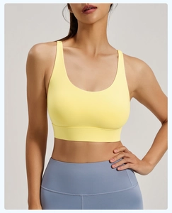Detailed view of yellow high-impact sports bra with wide straps and elastic supportive band