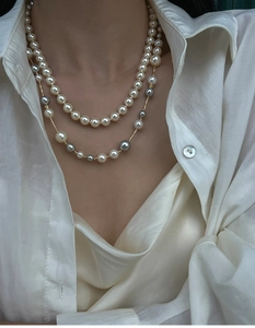 Close-up of double layer pearl necklace with white and grey pearls on a model