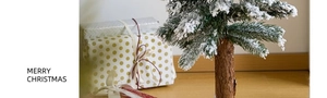 Miniature snowy Christmas tree and decorative gift boxes set for festive table display