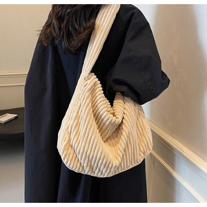Detail of soft beige corduroy tote bag showing textured vertical stripes and hobo style