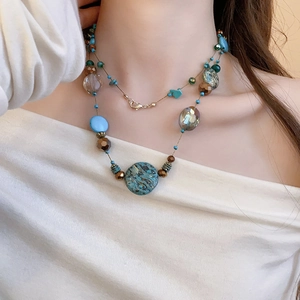 Detail of bohemian layered necklace with blue turquoise beads and antique metal spacers