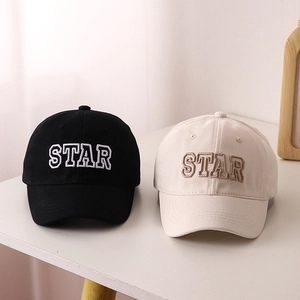 Close-up of star embroidery on black and beige cotton baseball caps for kids