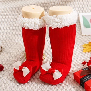 Detail of red Christmas socks with white sherpa fleece trim and a cute ribbon bow
