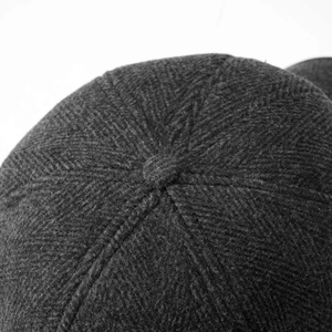 Detailed macro view of high-quality dark grey twill weave fabric and stitching on cap