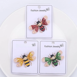 Detailed view of colorful enamel bee brooches with rhinestones on fashion jewelry cards