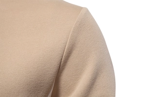 Close-up of beige knitted cotton sweatshirt showing shoulder seam detail and fabric texture