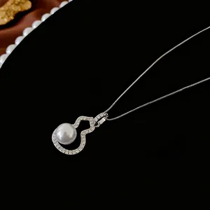 Silver wulu necklace pendant with zircon stones and white pearl on black velvet