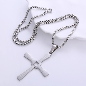 Polished stainless steel hinged cross necklace with engraved religious text on white tray