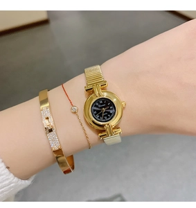 Close-up of DINIMI gold women's watch with Roman numerals and matching bracelets