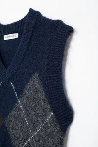 Detailaufnahme der Strickweste mit V-Ausschnitt, Rautenmuster in Marineblau und weicher Textur