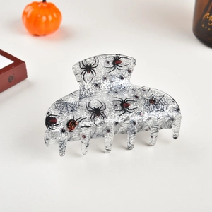 Detail of glittery Halloween hair claw clip with spider web patterns and spider motifs