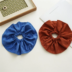 Detailed texture of blue and reddish brown oversized fabric scrunchies in soft velvet