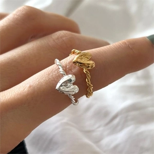 Macro shot of minimalist twisted rope heart rings in gold and silver finishes