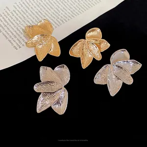 Golden and silver textured leaf petal stud earrings with tiered layered metal design